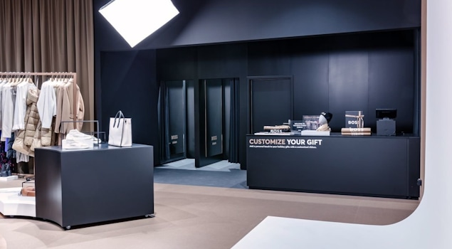 The BOSS Studio in Zurich embodies an avant-garde retail concept within a 250-square-meter space. With a nod to the brand's essence, a vibrant customisation corner and captivating window displays adorned with flashlights enchant passersby. Retail design by Studio Königshausen.
